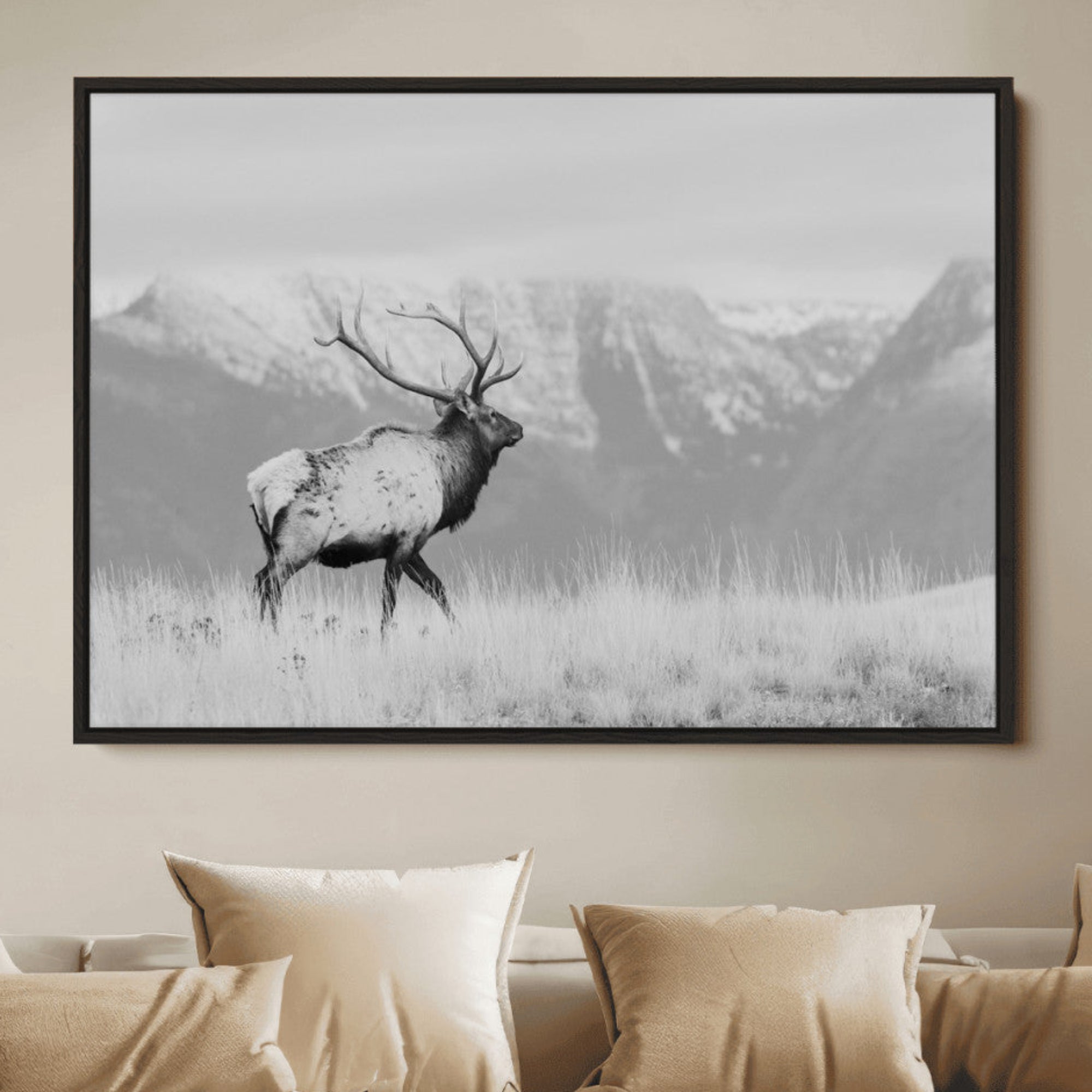 Black and white elk with antlers walking in a field, snowy mountain backdrop, ideal for rustic lodge or minimalist wall decor.