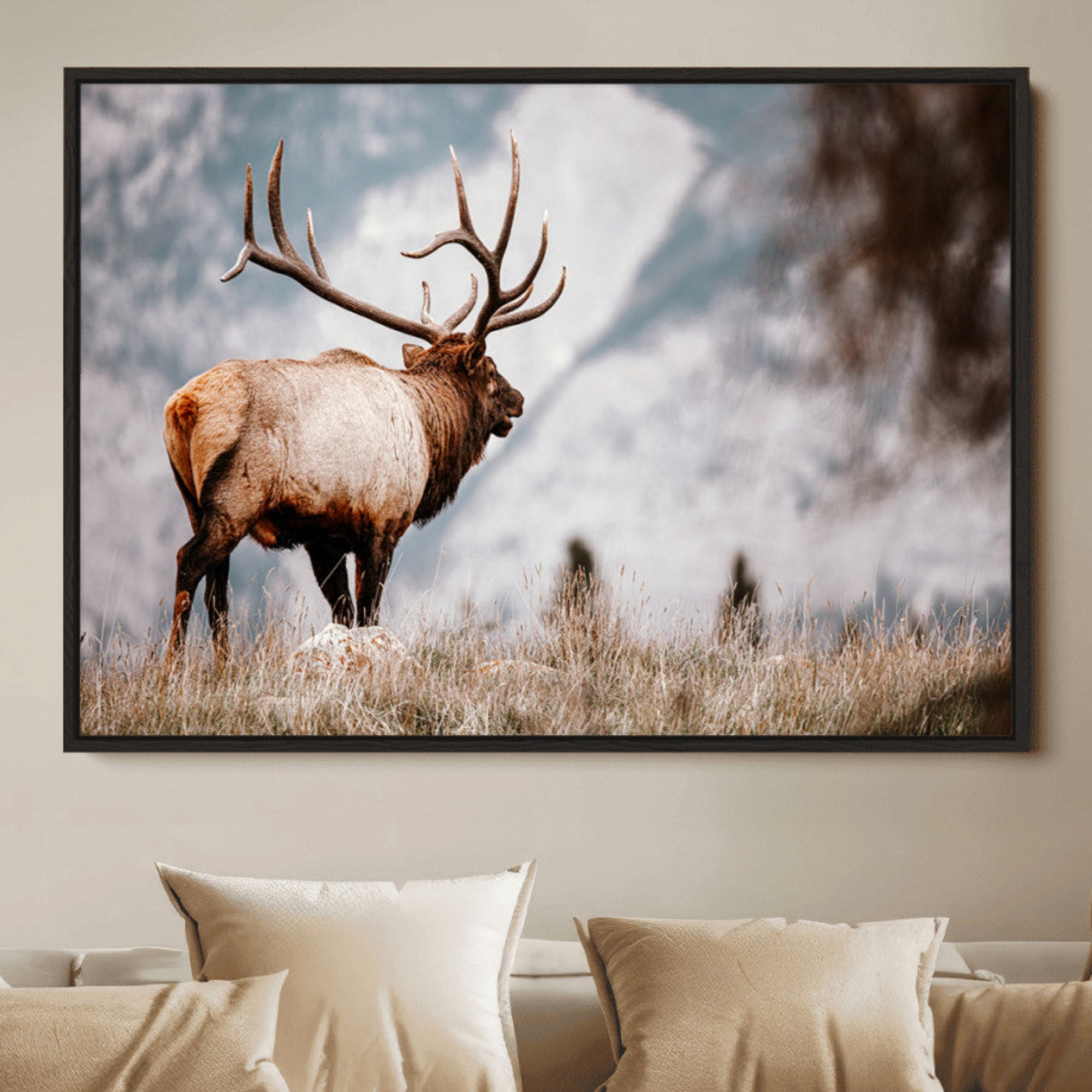 Majestic elk with large antlers standing in grass with snowy mountains in background, perfect for rustic cabin or lodge style decor.