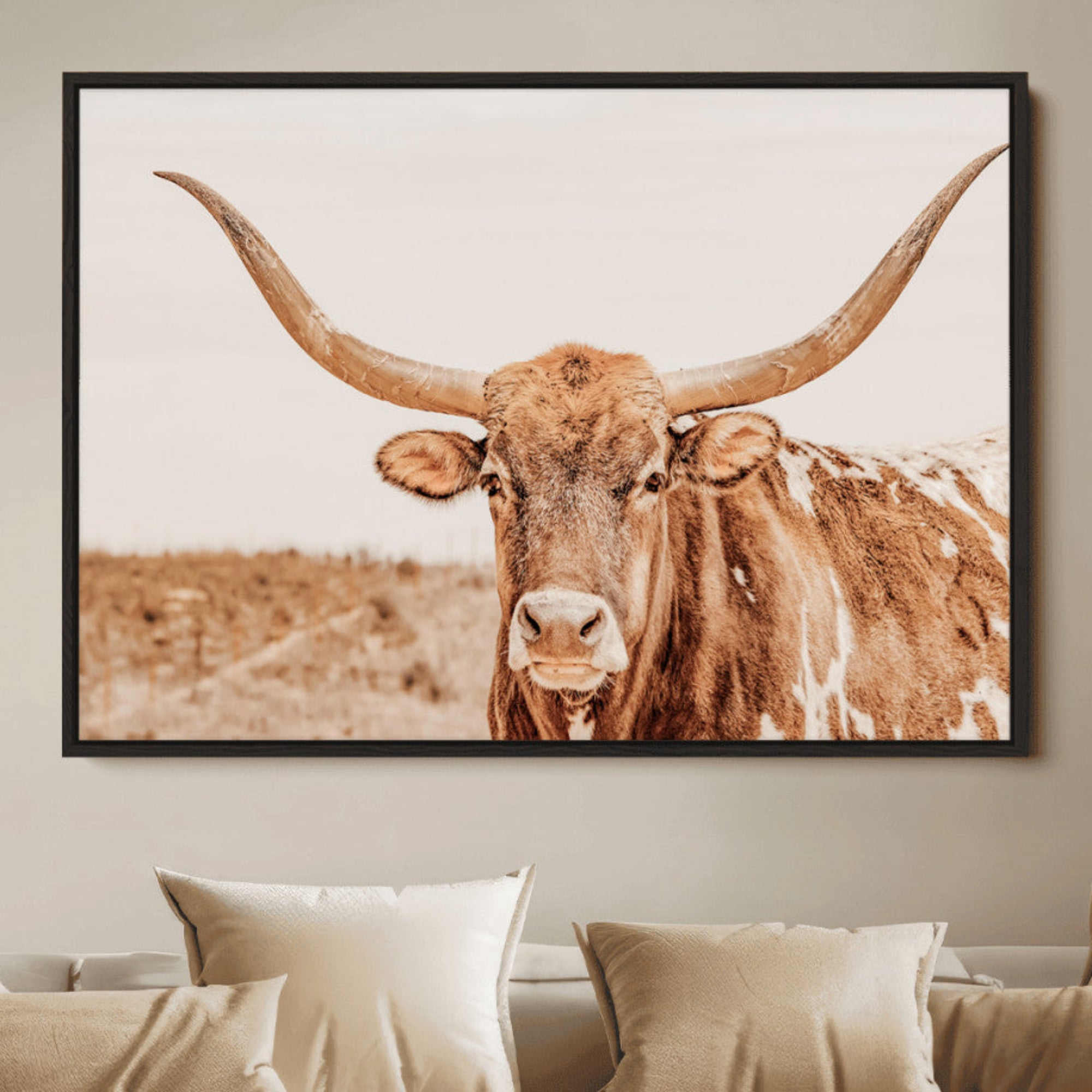 A longhorn bull standing proudly in a sunlit desert field with warm neutral tones, ideal for rustic western or farmhouse interiors.