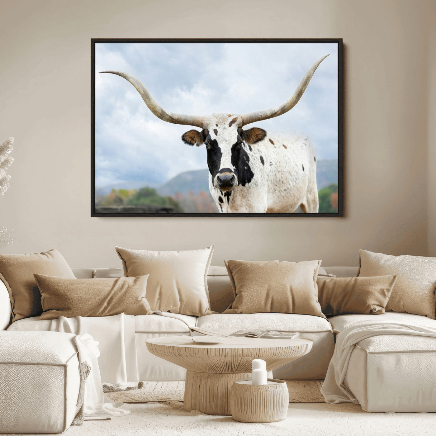 Close-up of a Texas Longhorn with curved horns, black and white markings, set against a cloudy sky and distant hills, perfect for rustic decor.