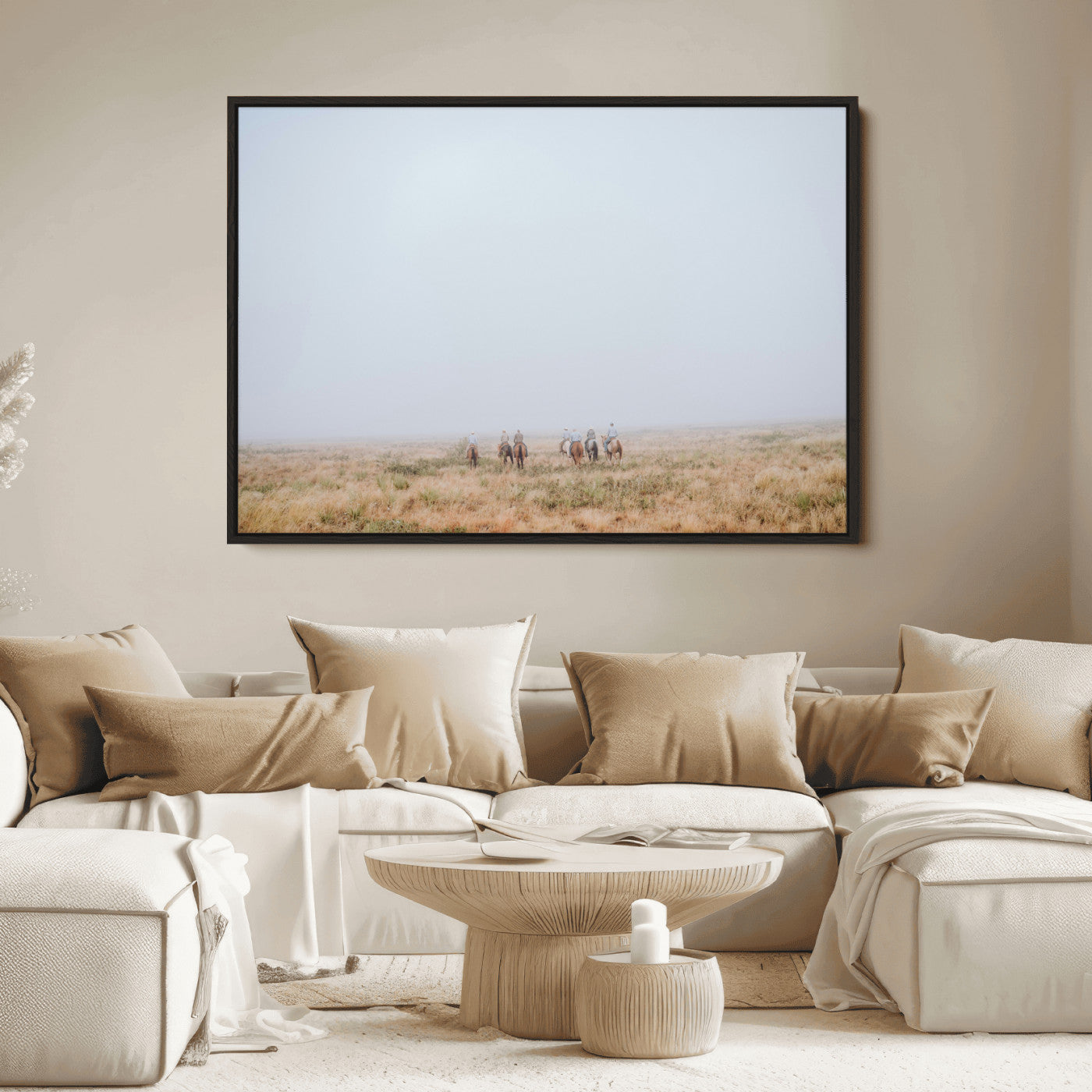 A group of horseback riders moving through a fog-shrouded field, evoking a calm Western scene with golden grasses and soft horizons.