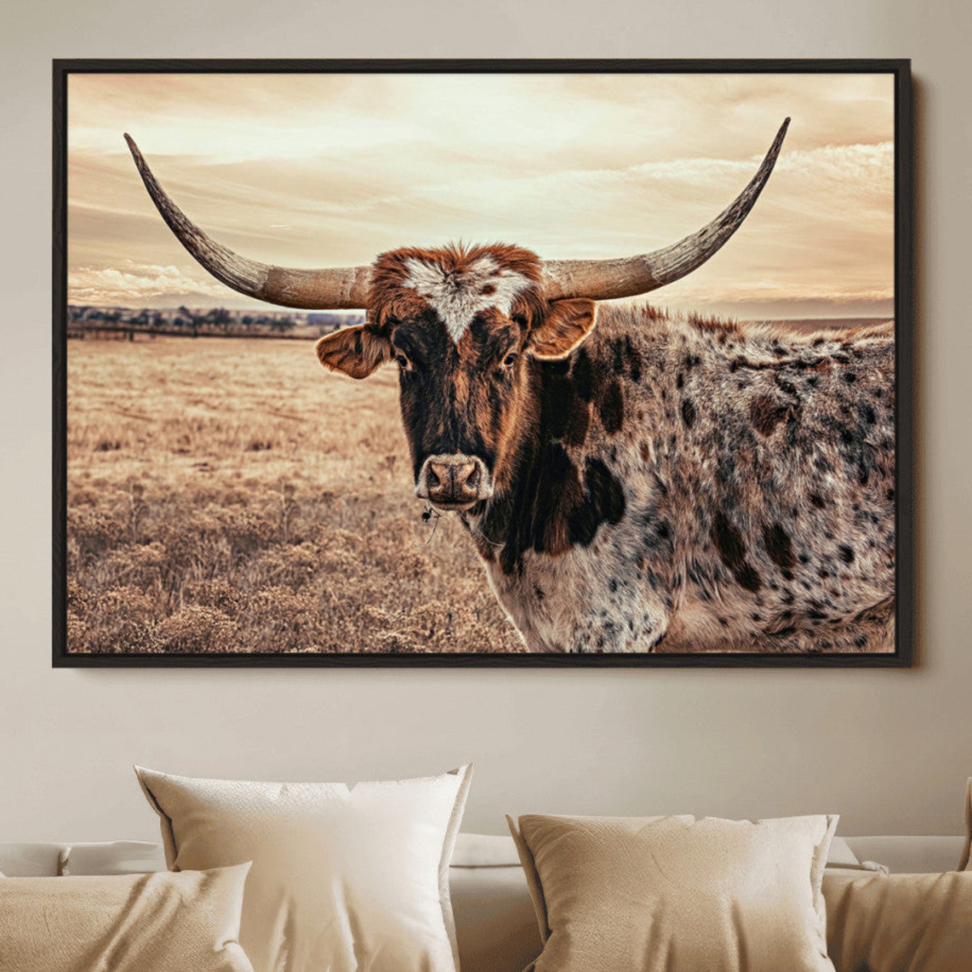 Close-up of a longhorn cow with distinctive curved horns standing in a dry grass field under a cloudy sky.