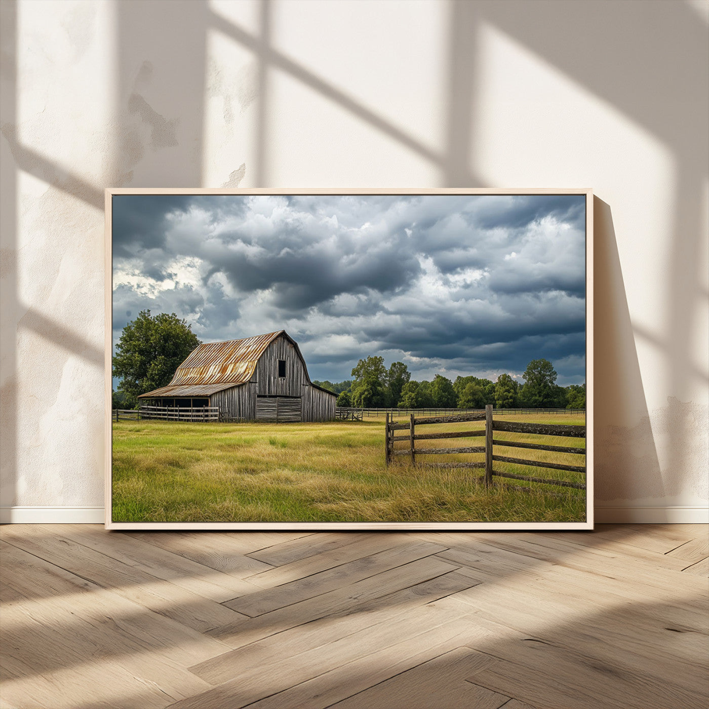 "Rustic barn in a wide open field under a dramatic sky with dark clouds, surrounded by a wooden fence and lush green trees."