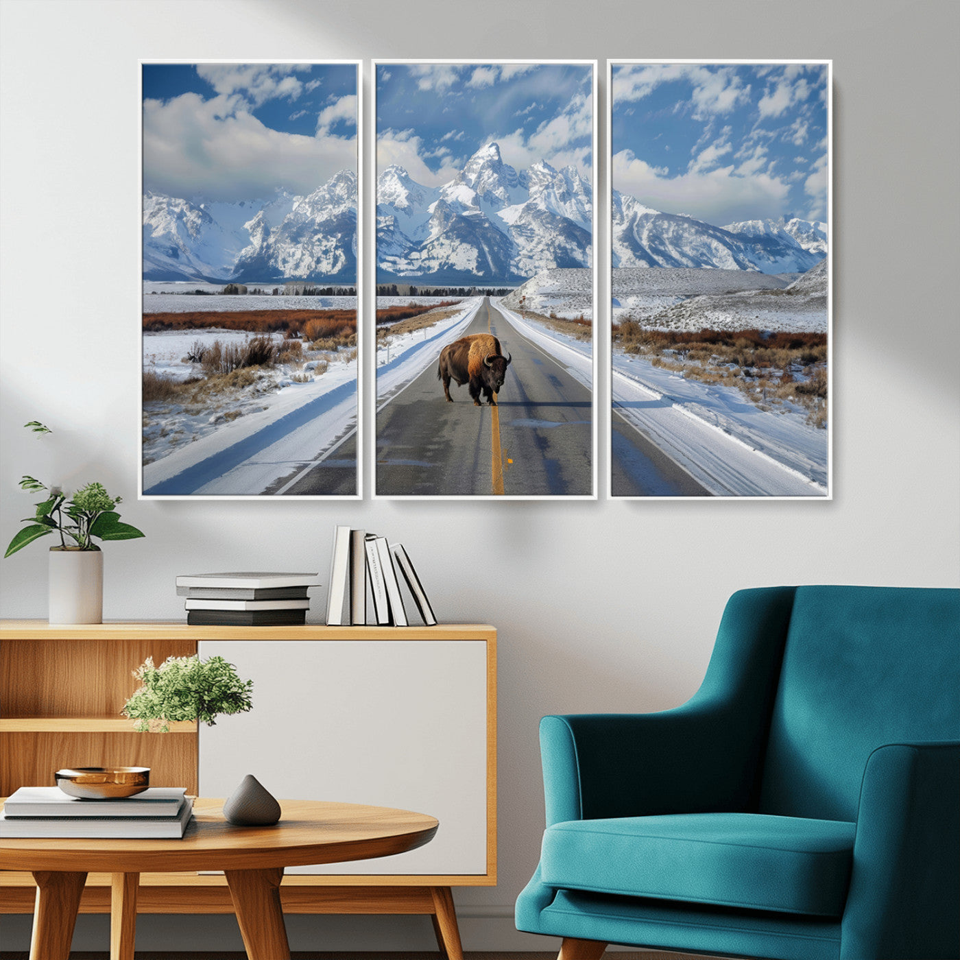 A powerful bison stands on a snow-dusted road beneath the towering peaks of the Grand Tetons, capturing the untamed beauty of America's winter wilderness.
