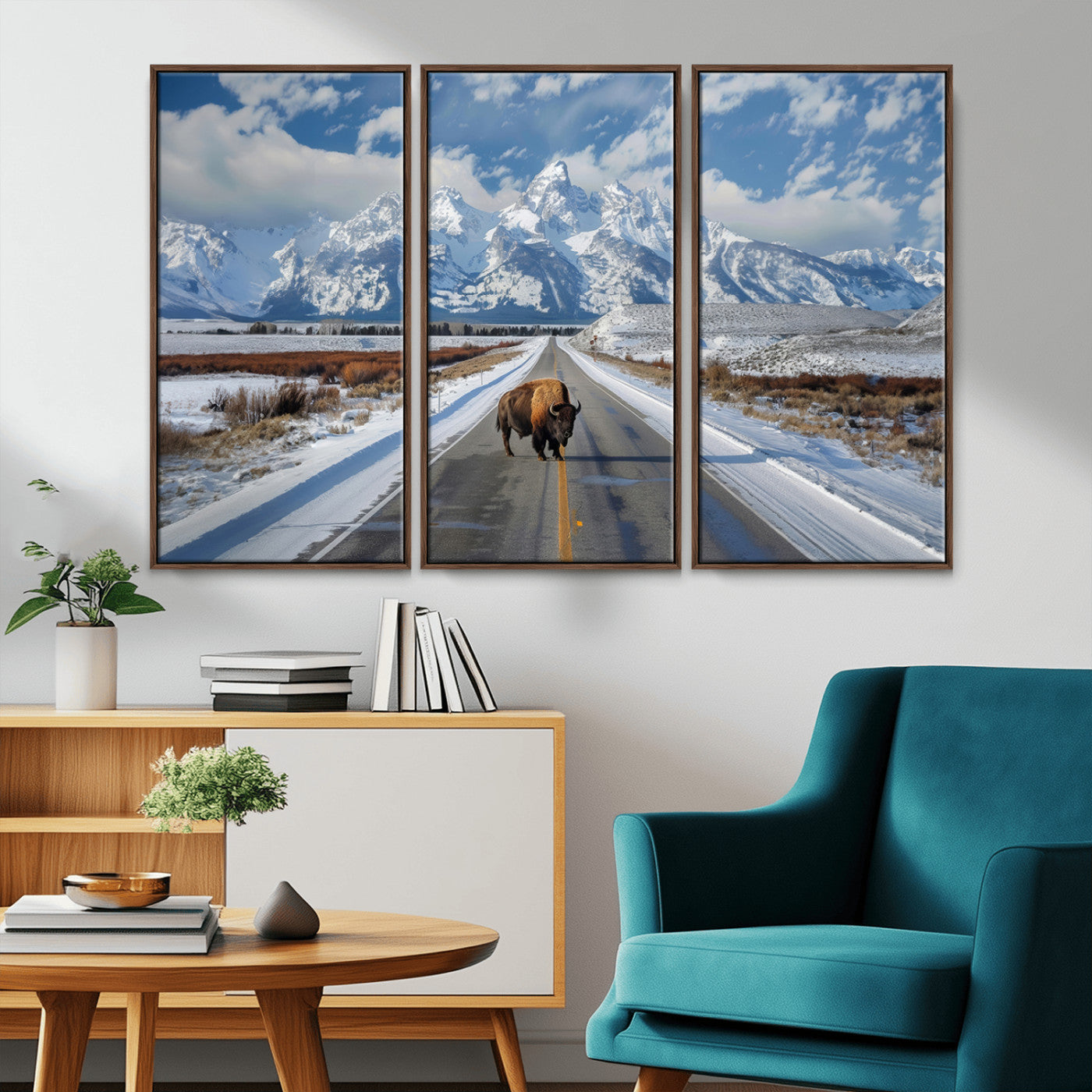 A powerful bison stands on a snow-dusted road beneath the towering peaks of the Grand Tetons, capturing the untamed beauty of America's winter wilderness.