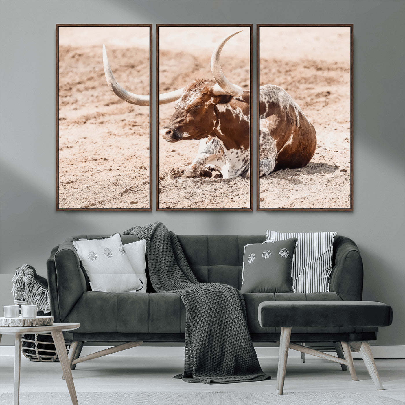 Texas Longhorn bull resting on dusty ground with warm tones, ideal for rustic western or farmhouse-themed wall decor.