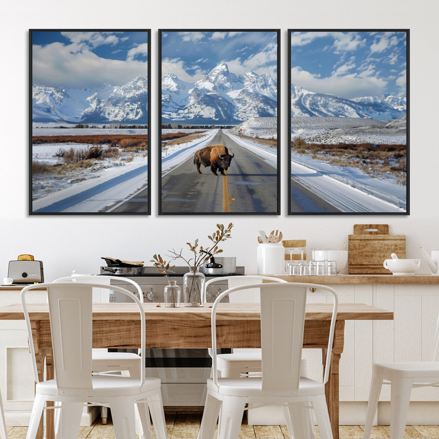 A powerful bison stands on a snow-dusted road beneath the towering peaks of the Grand Tetons, capturing the untamed beauty of America's winter wilderness.