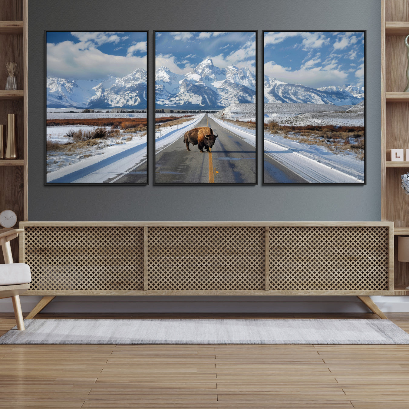 A powerful bison stands on a snow-dusted road beneath the towering peaks of the Grand Tetons, capturing the untamed beauty of America's winter wilderness.