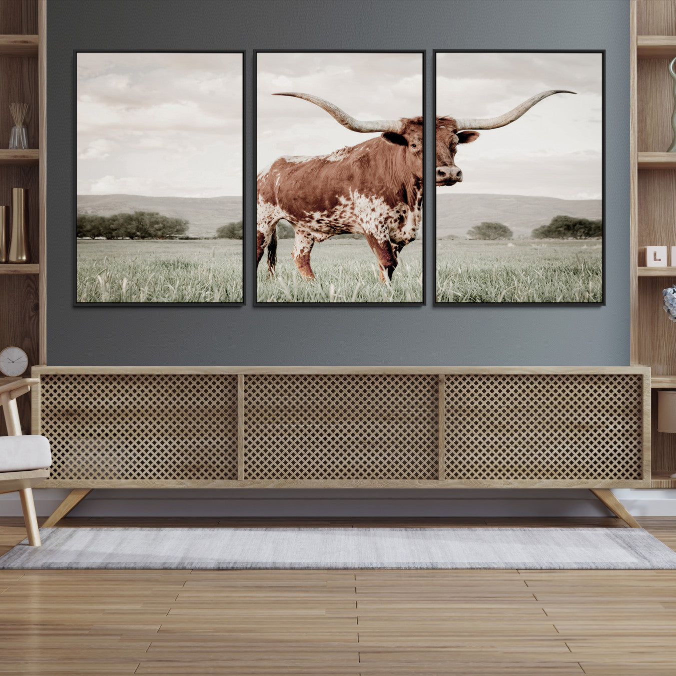 Canvas of a Texas longhorn standing in a grassy field with mountains in the background, ideal for rustic or country-style western wall decor.