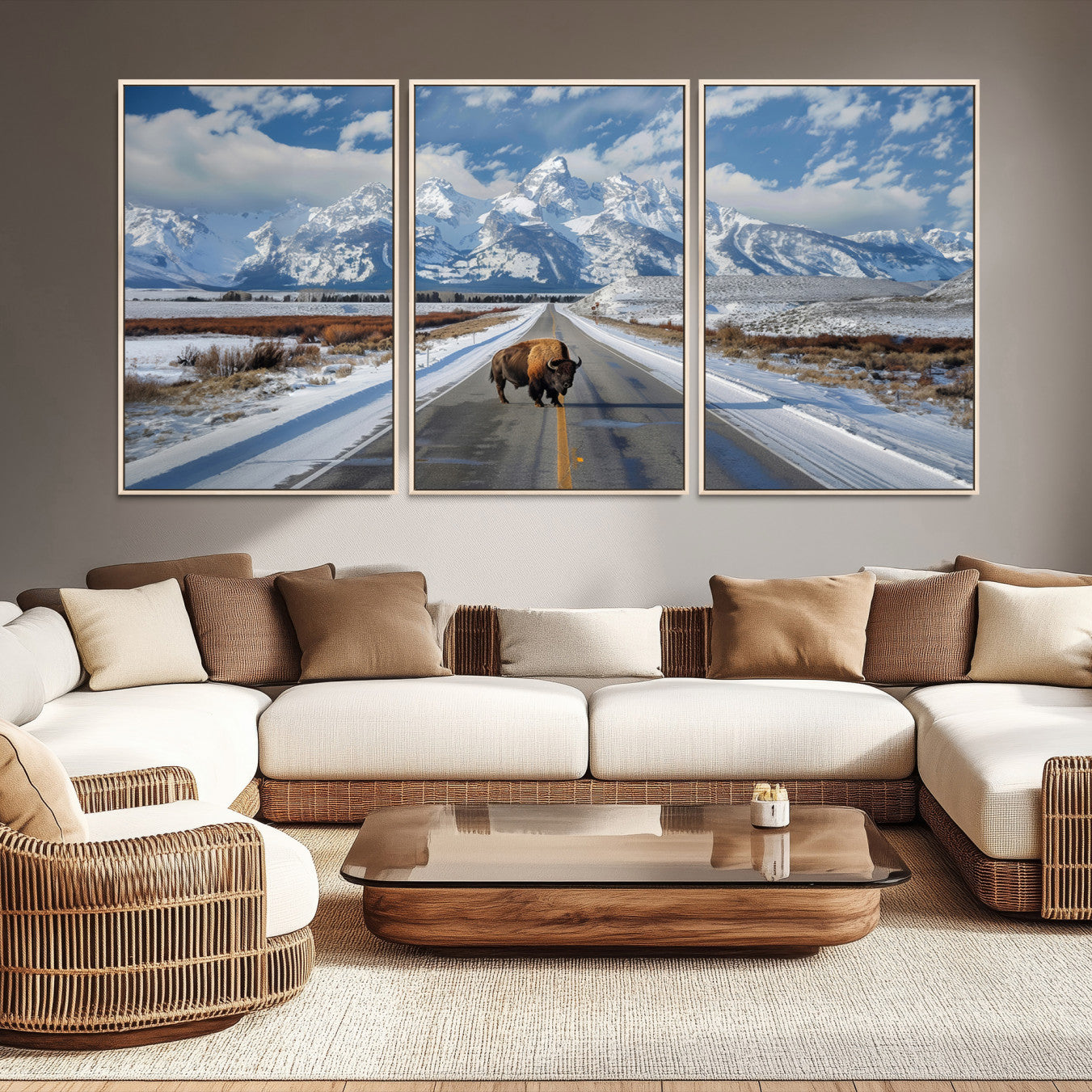 A powerful bison stands on a snow-dusted road beneath the towering peaks of the Grand Tetons, capturing the untamed beauty of America's winter wilderness.