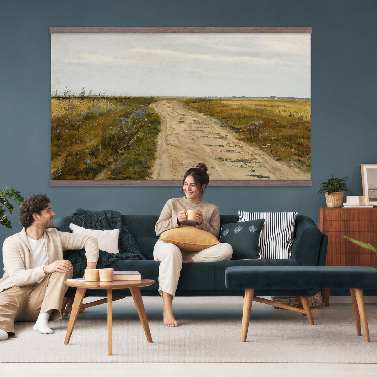 93198256-MGV-TP-30X20 - Realism oil painting tapestry wall hanging of "Field Track" by Jozef Chelmonski, showing a rutted dirt track cutting through open meadow grass toward a low horizon and a wide country sky in warm earth track tones with green meadow grass under a broad sky. Extra large wall art, made in the USA.