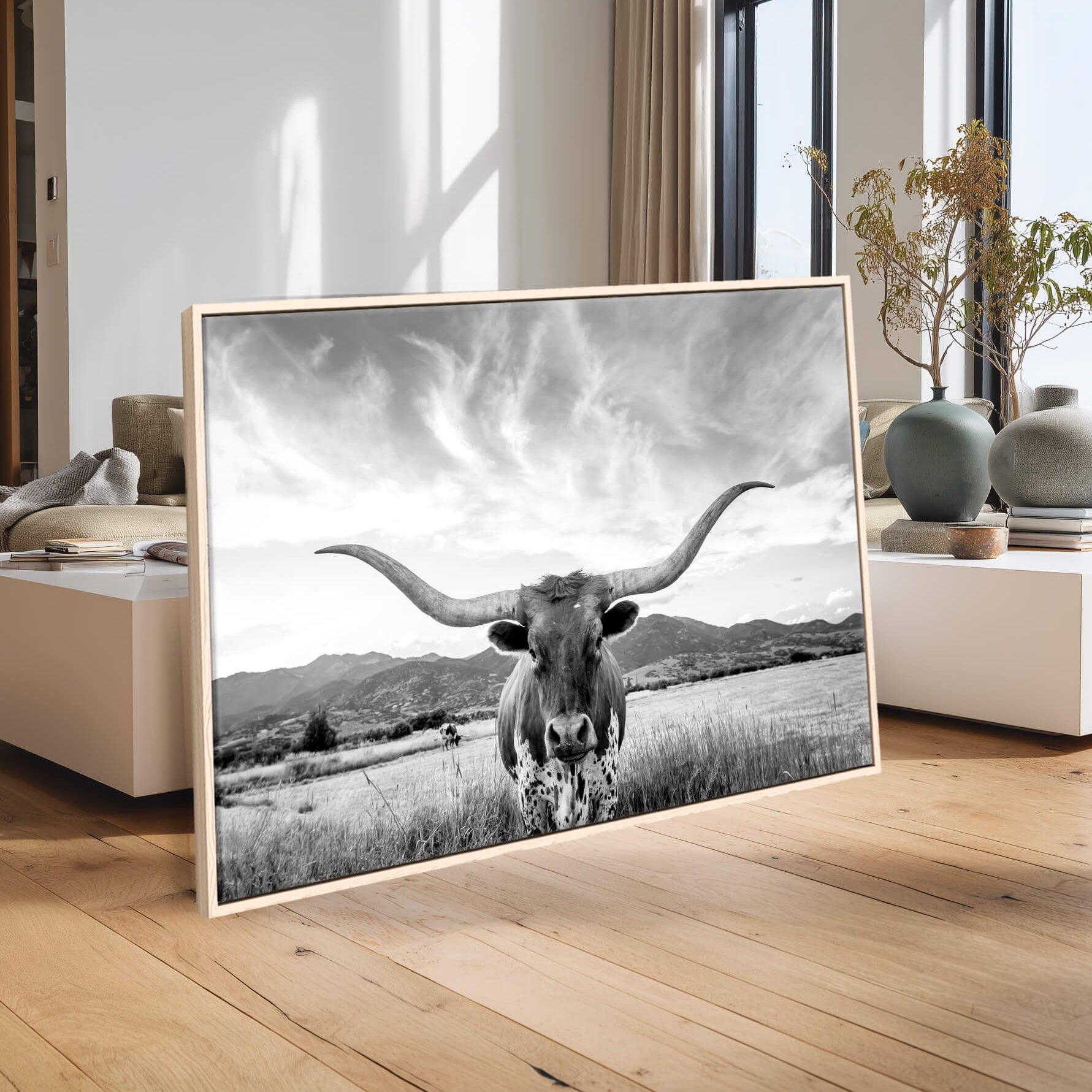 Framed black and white photo of a longhorn cow in a modern living room.