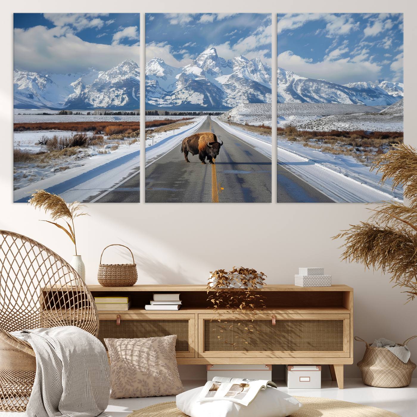A powerful bison stands on a snow-dusted road beneath the towering peaks of the Grand Tetons, capturing the untamed beauty of America's winter wilderness.