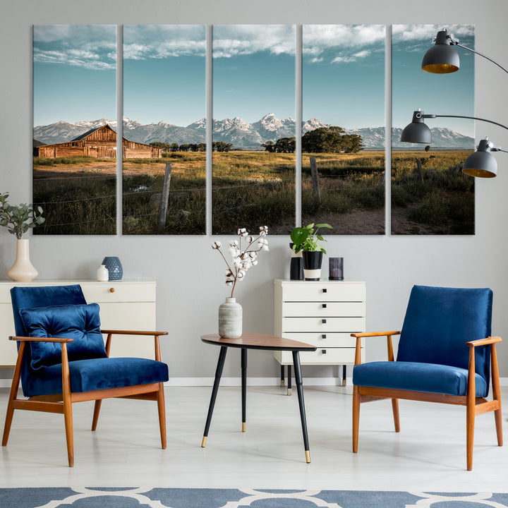 A rustic farmhouse with a wooden barn set against majestic mountain peaks under a soft blue sky, evoking peaceful countryside charm.