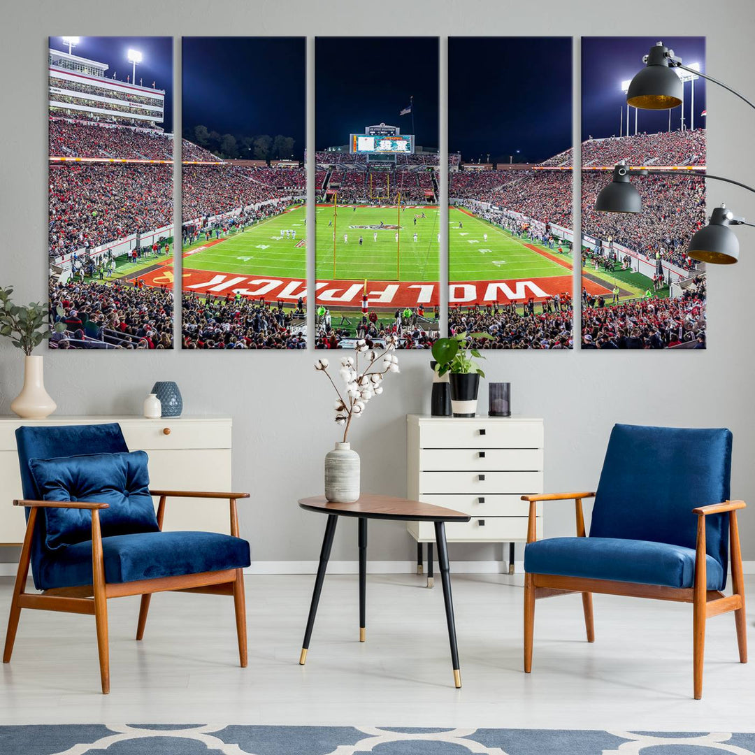 A NC State Wolfpack Football Team print of Carter-Finley Stadium at night features WOLFPACK illuminated brightly in the end zone grass.