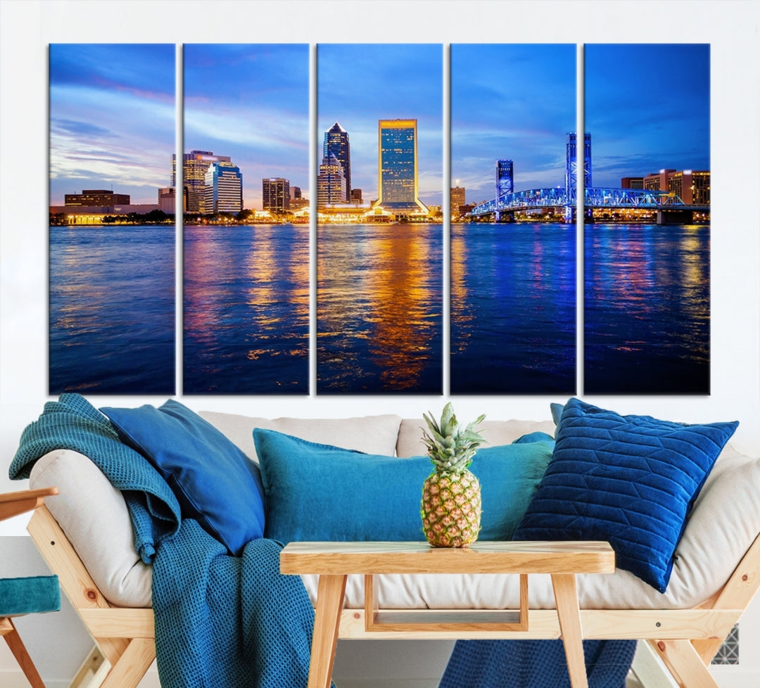 A cozy living room features the Jacksonville Wall Art Canvas Print, a large triptych crafted on museum-quality canvas that beautifully depicts the Jacksonville city skyline at sunset.