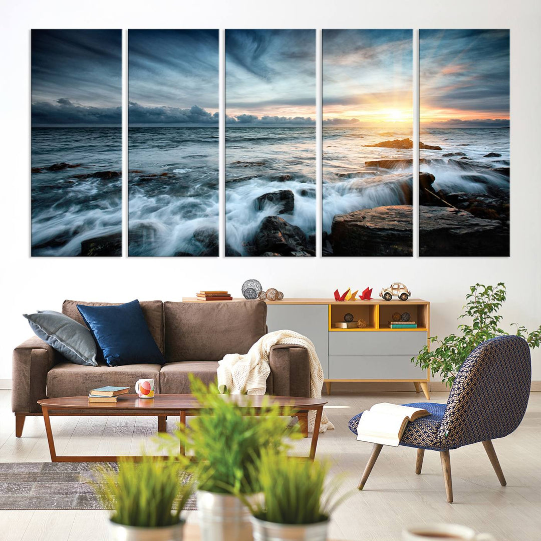 Dynamic Ocean Waves Triptych Canvas Art, a stunning giclee canvas print showcasing a dramatic ocean sunrise with waves crashing on rocks, hangs prominently to create a captivating coastal ambiance.