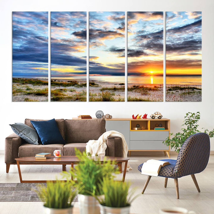 The Sunset On The Ocean canvas wall art features a beautiful beach sunset with grass and clouds.