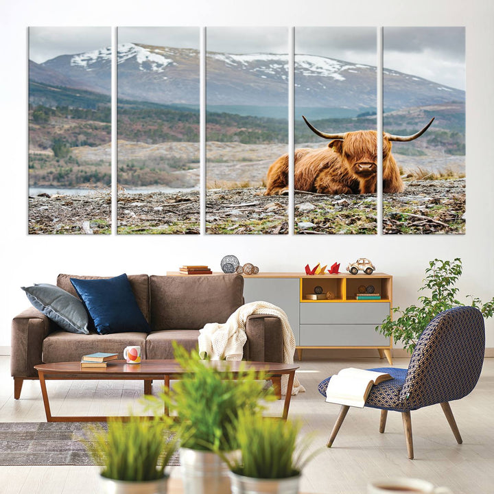 Highland Cow Horn Farm Wall Art Canvas Print is displayed against a wooden wall featuring a mountainous backdrop.