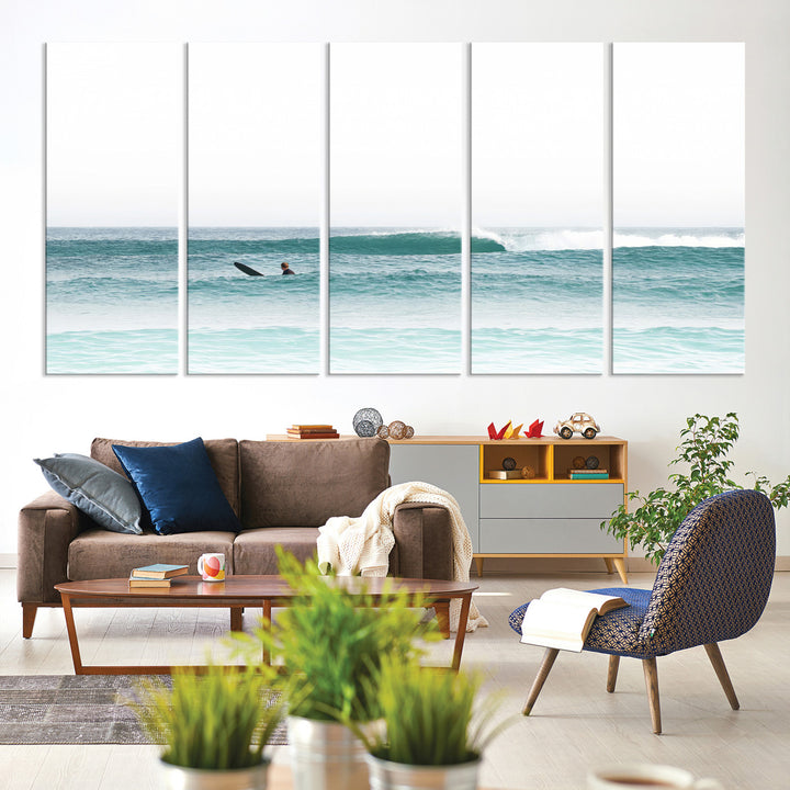 Minimalist photo of a lone surfer on calm aqua waves under bright sky, perfect for Scandinavian coastal or serene ocean-inspired home decor.