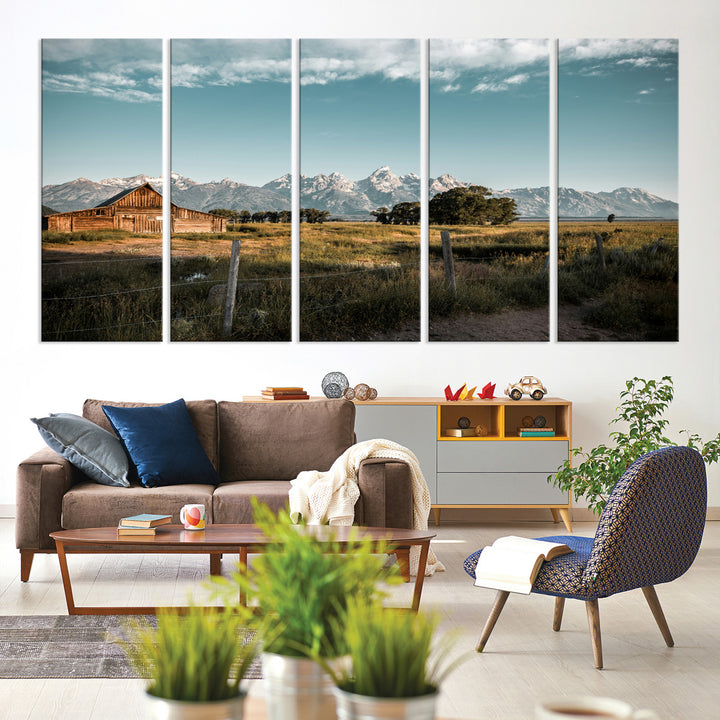 A rustic farmhouse with a wooden barn set against majestic mountain peaks under a soft blue sky, evoking peaceful countryside charm.