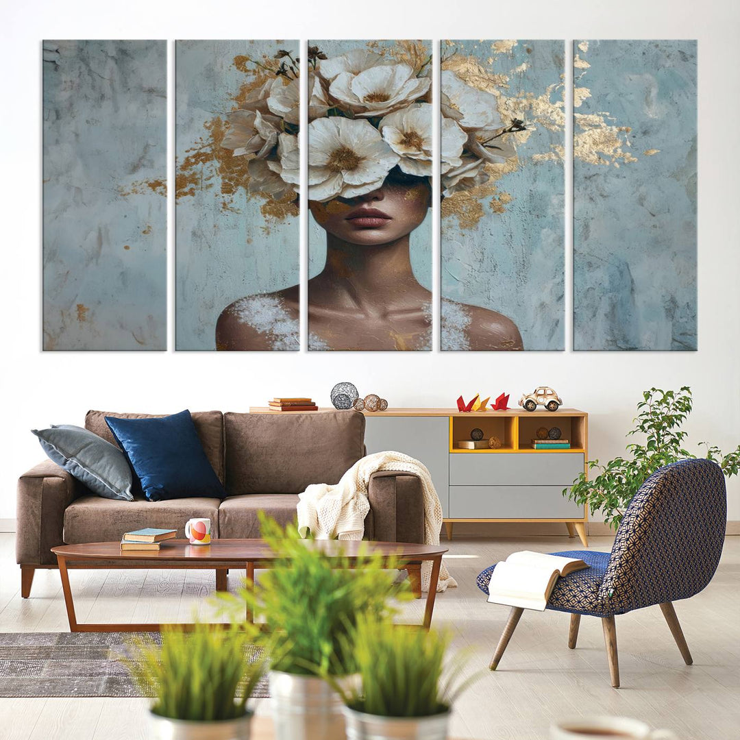 The Golden Petal Silhouette Woman Wall Art Canvas Print, a large 3-panel canvas with a textured gold floral design, serves as a luxurious centerpiece in modern glam settings. The artwork depicts a woman with flowers over her eyes against a textured background and hangs elegantly.