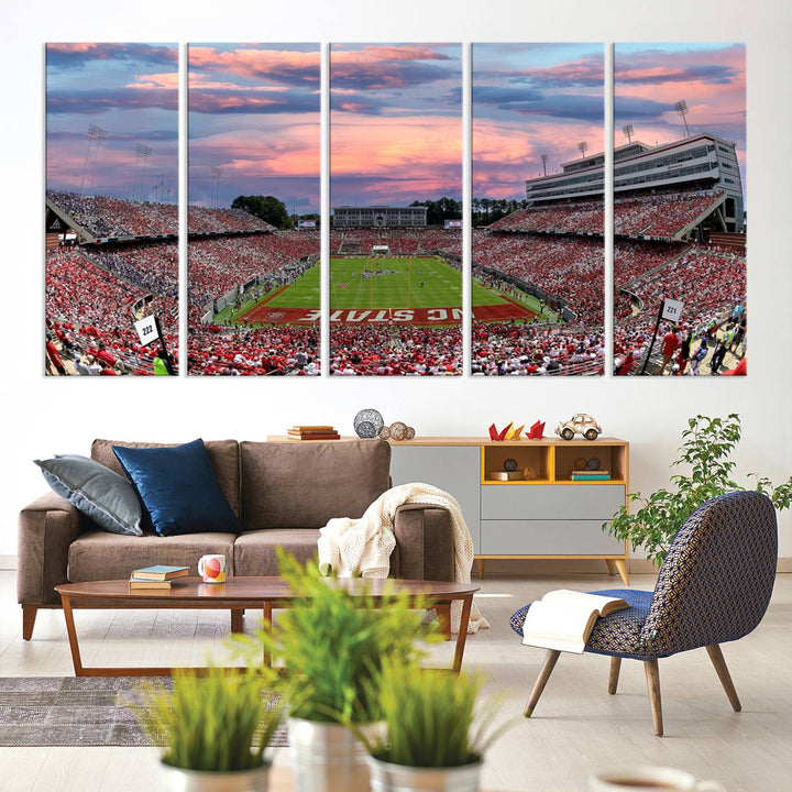 The wall art captures an NC State Wolfpack game under a vibrant sunset on triple canvas.