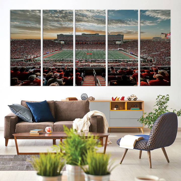 The living room features a stunning triptych of Lincoln Memorial Stadium wall art canvas print, celebrating the University of Nebraska Cornhuskers football team. This piece serves as captivating wall art, showcasing a gallery-quality finish.