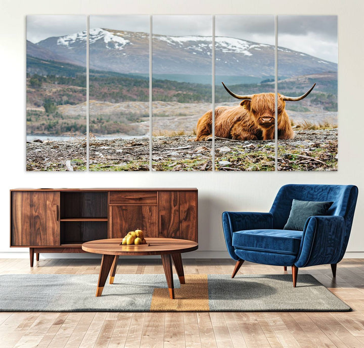 Highland Cow Horn Farm Wall Art Canvas Print is displayed against a wooden wall featuring a mountainous backdrop.