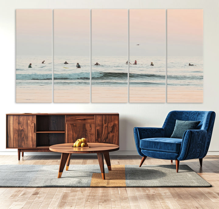 Dreamy photo of surfers waiting on soft pastel waves under a pink sunset sky, ideal for soft coastal minimalist or serene ocean-themed home decor.