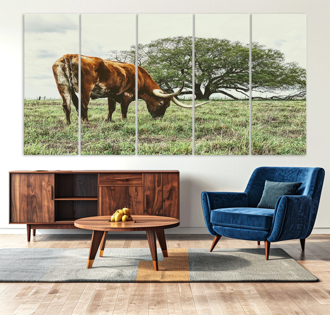 A Texas Longhorn grazing in a green pasture with a large tree in the background, evoking a rustic Western and farmhouse aesthetic.