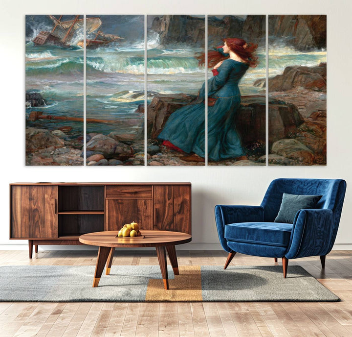 The Miranda by the Shore Wall Art Canvas Print depicts a woman in a blue dress standing by the sea, watching a shipwreck.