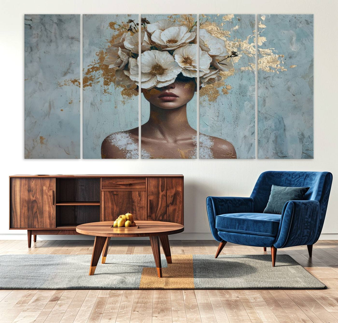 The Golden Petal Silhouette Woman Wall Art Canvas Print, a large 3-panel canvas with a textured gold floral design, serves as a luxurious centerpiece in modern glam settings. The artwork depicts a woman with flowers over her eyes against a textured background and hangs elegantly.