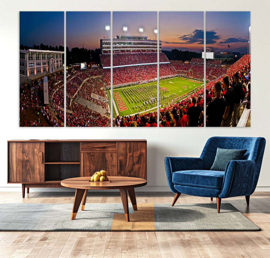 A print of a bustling Carter-Finley Stadium at dusk, featuring fans and a band, captures the essence of NC State Wolfpack football.