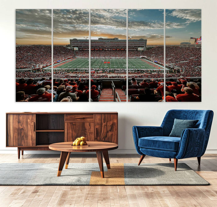 The living room features a stunning triptych of Lincoln Memorial Stadium wall art canvas print, celebrating the University of Nebraska Cornhuskers football team. This piece serves as captivating wall art, showcasing a gallery-quality finish.