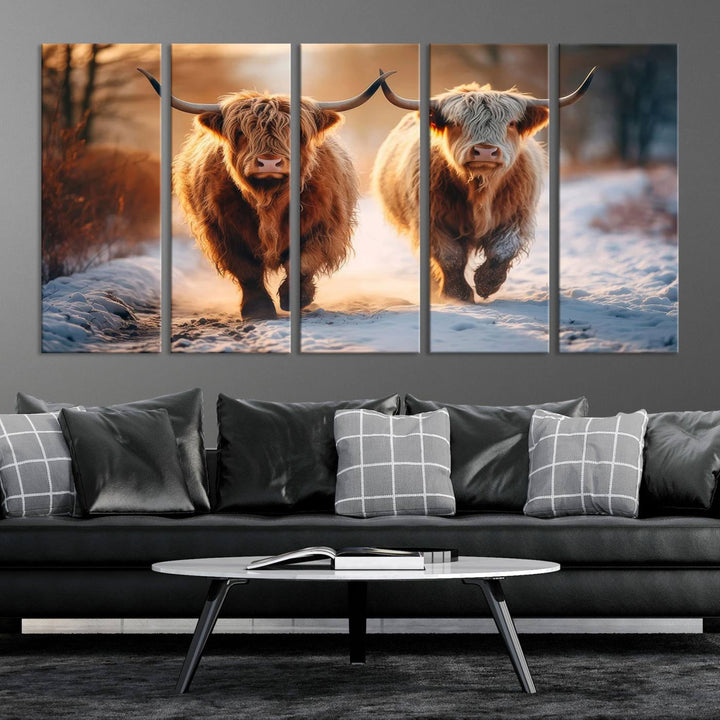 The wall art is a Scottish Highland Cow Horn canvas print featuring cows on a snowy path bathed in warm sunlight, serving as a rustic decor piece.