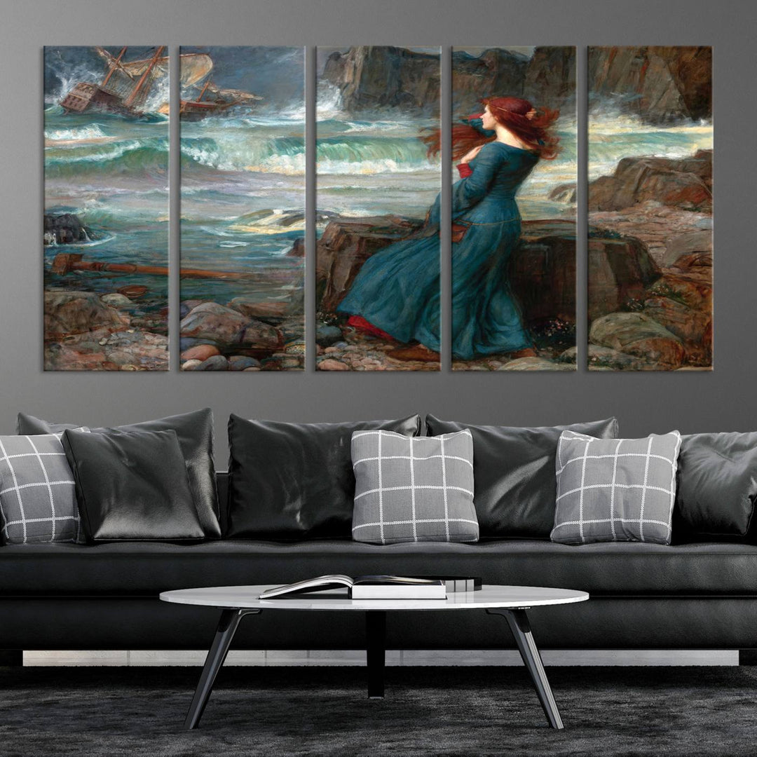 The Miranda by the Shore Wall Art Canvas Print depicts a woman in a blue dress standing by the sea, watching a shipwreck.