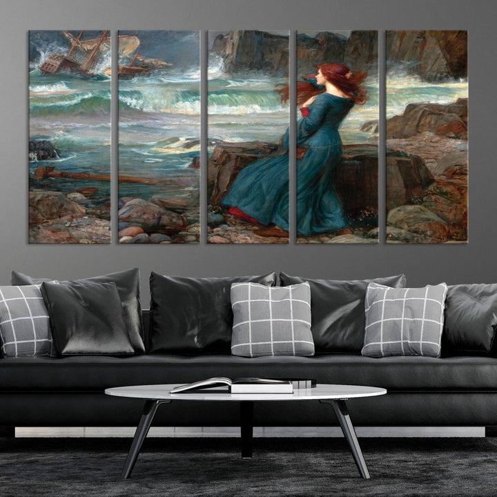 The Miranda by the Shore Wall Art Canvas Print depicts a woman in a blue dress standing by the sea, watching a shipwreck.