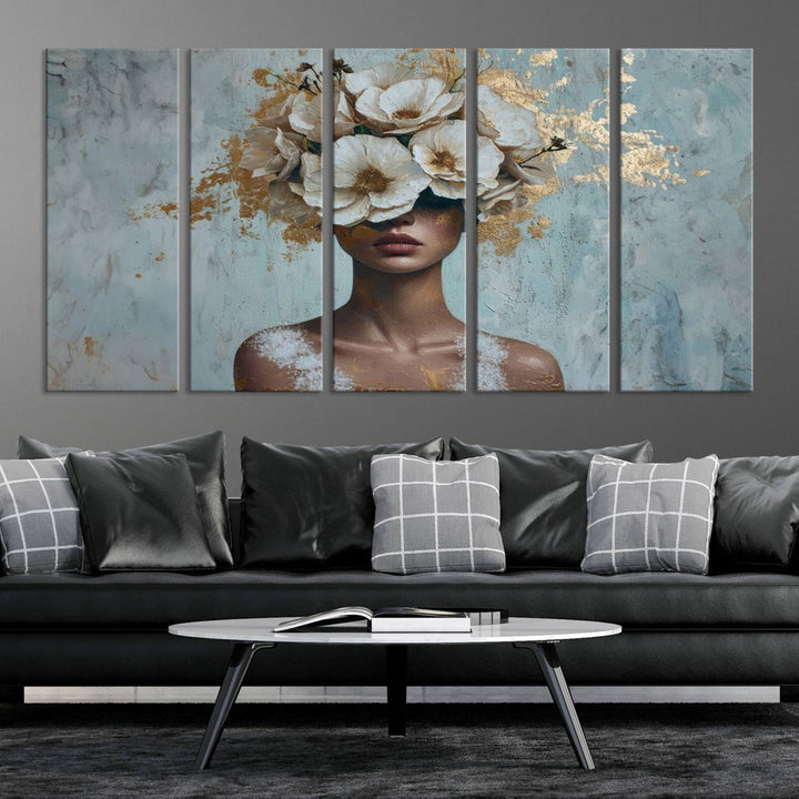 The Golden Petal Silhouette Woman Wall Art Canvas Print, a large 3-panel canvas with a textured gold floral design, serves as a luxurious centerpiece in modern glam settings. The artwork depicts a woman with flowers over her eyes against a textured background and hangs elegantly.