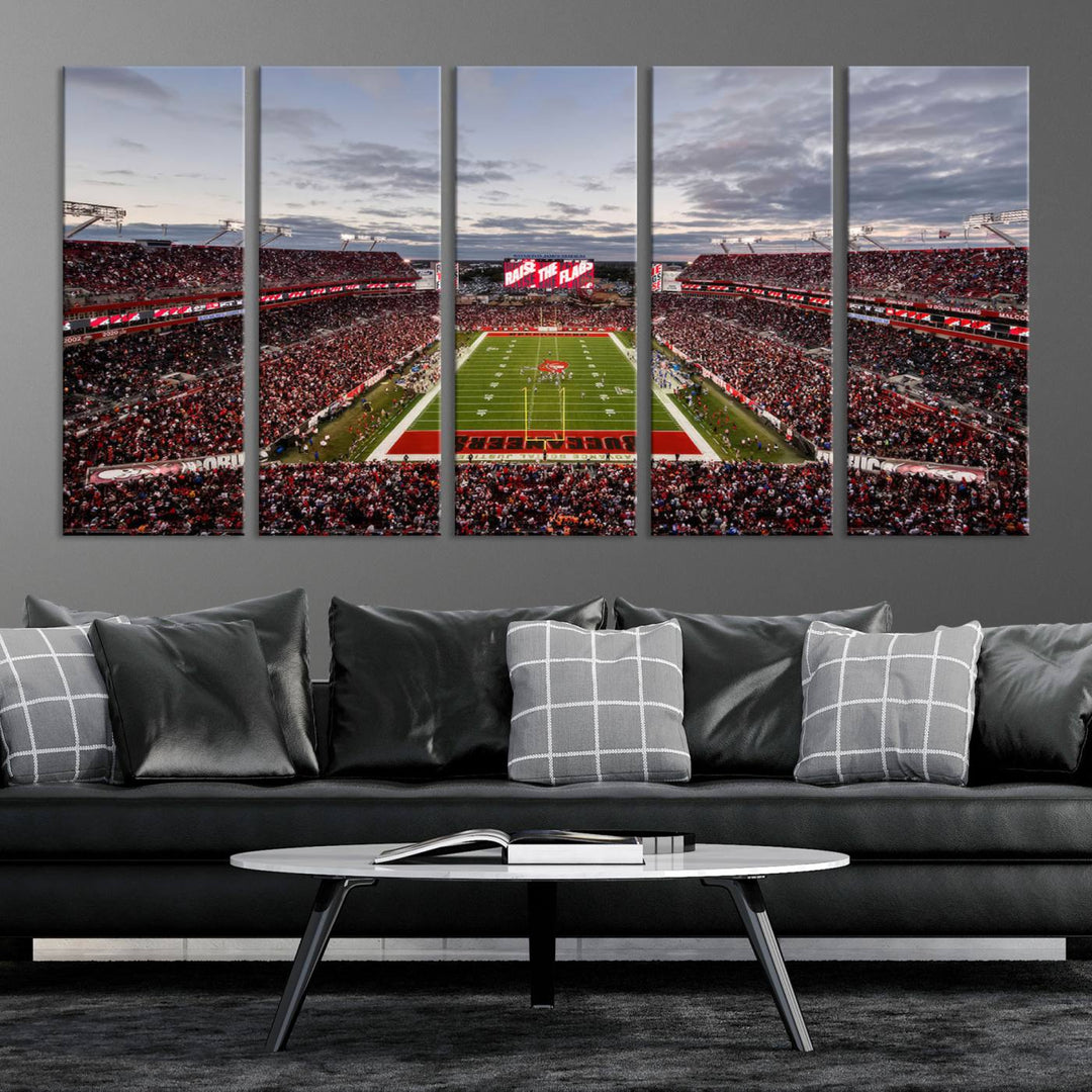 The wall art captures a stunning scene of Raymond James Stadium bathed in the warm hues of sunset. The sky, filled with clouds, provides a dramatic contrast to the vibrant lighting on the field, encapsulating the dynamic energy of a football game.