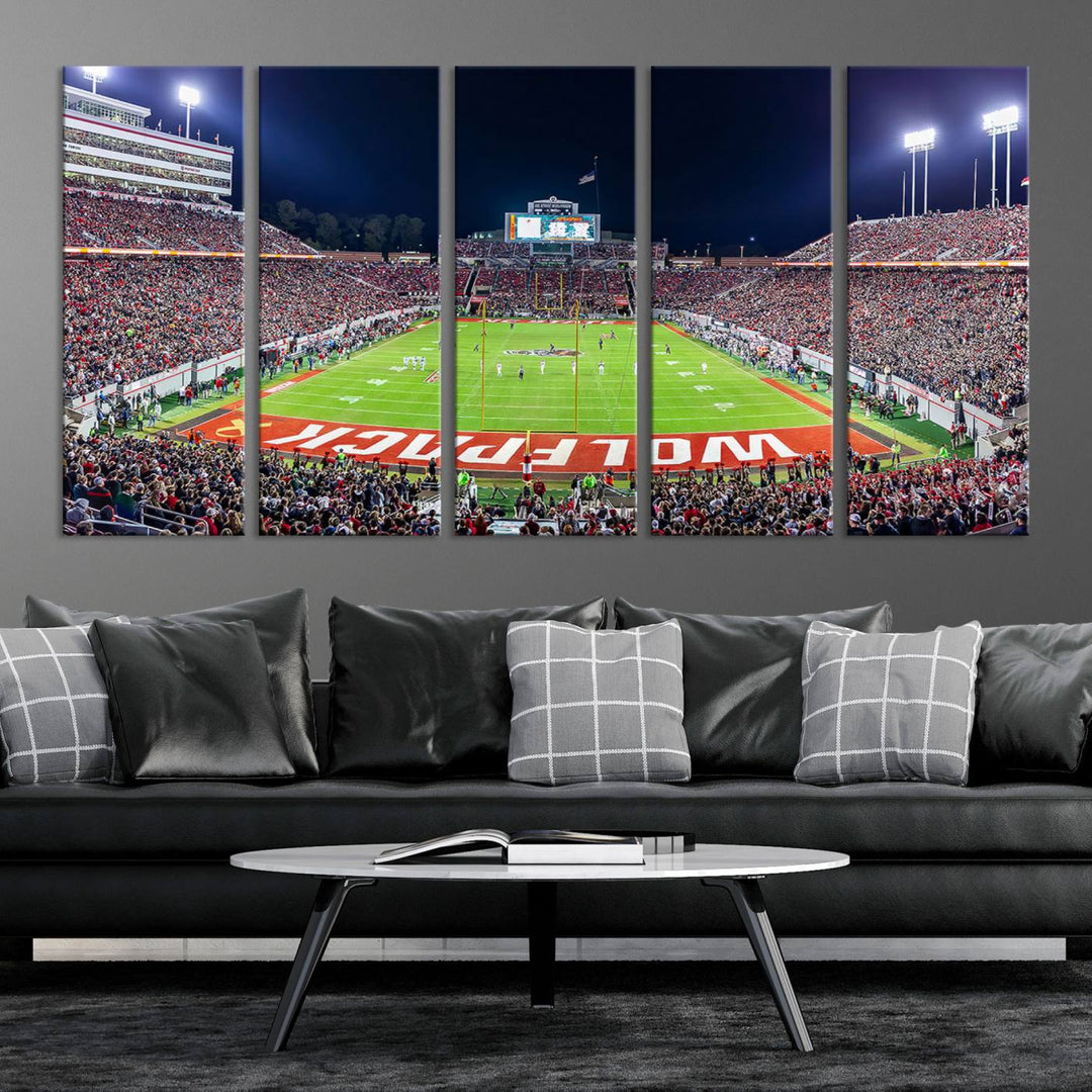 A NC State Wolfpack Football Team print of Carter-Finley Stadium at night features WOLFPACK illuminated brightly in the end zone grass.