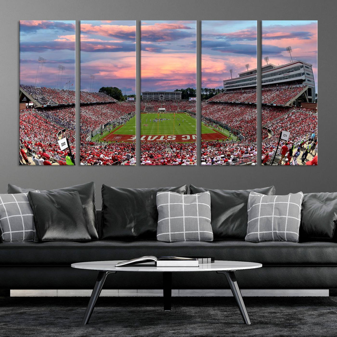 The wall art captures an NC State Wolfpack game under a vibrant sunset on triple canvas.