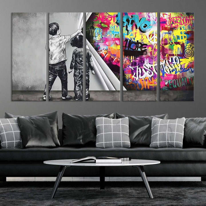 The Banksy Print - Street Art Canvas features a vibrant and bold image of two children lifting a curtain to reveal colorful graffiti. It's ready to hang, adding an urban modern decor vibe.