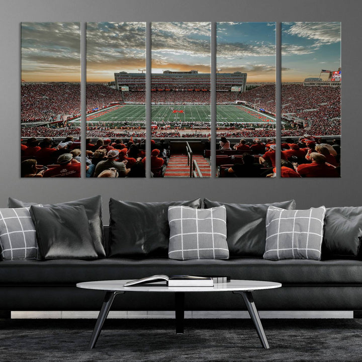 The living room features a stunning triptych of Lincoln Memorial Stadium wall art canvas print, celebrating the University of Nebraska Cornhuskers football team. This piece serves as captivating wall art, showcasing a gallery-quality finish.