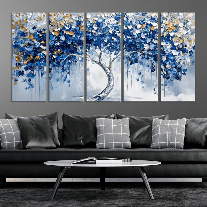 The Blue and Gold Abstract Tree Wall Art showcases a swirl trunk and features blue, silver, and gold leaves on a framed canvas print.