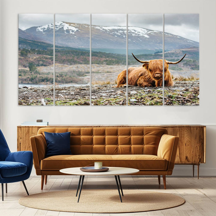 Highland Cow Horn Farm Wall Art Canvas Print is displayed against a wooden wall featuring a mountainous backdrop.