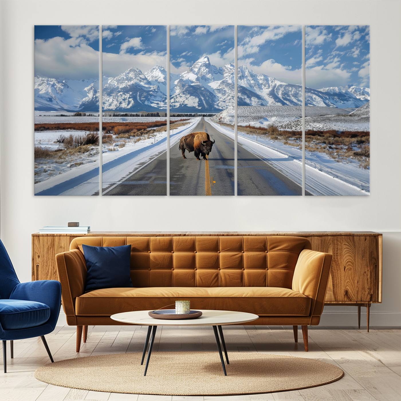 A powerful bison stands on a snow-dusted road beneath the towering peaks of the Grand Tetons, capturing the untamed beauty of America's winter wilderness.