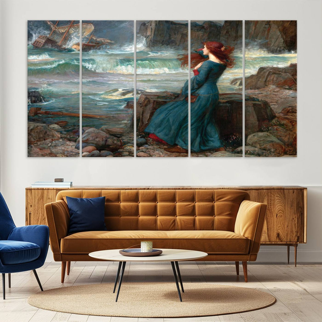 The Miranda by the Shore Wall Art Canvas Print depicts a woman in a blue dress standing by the sea, watching a shipwreck.