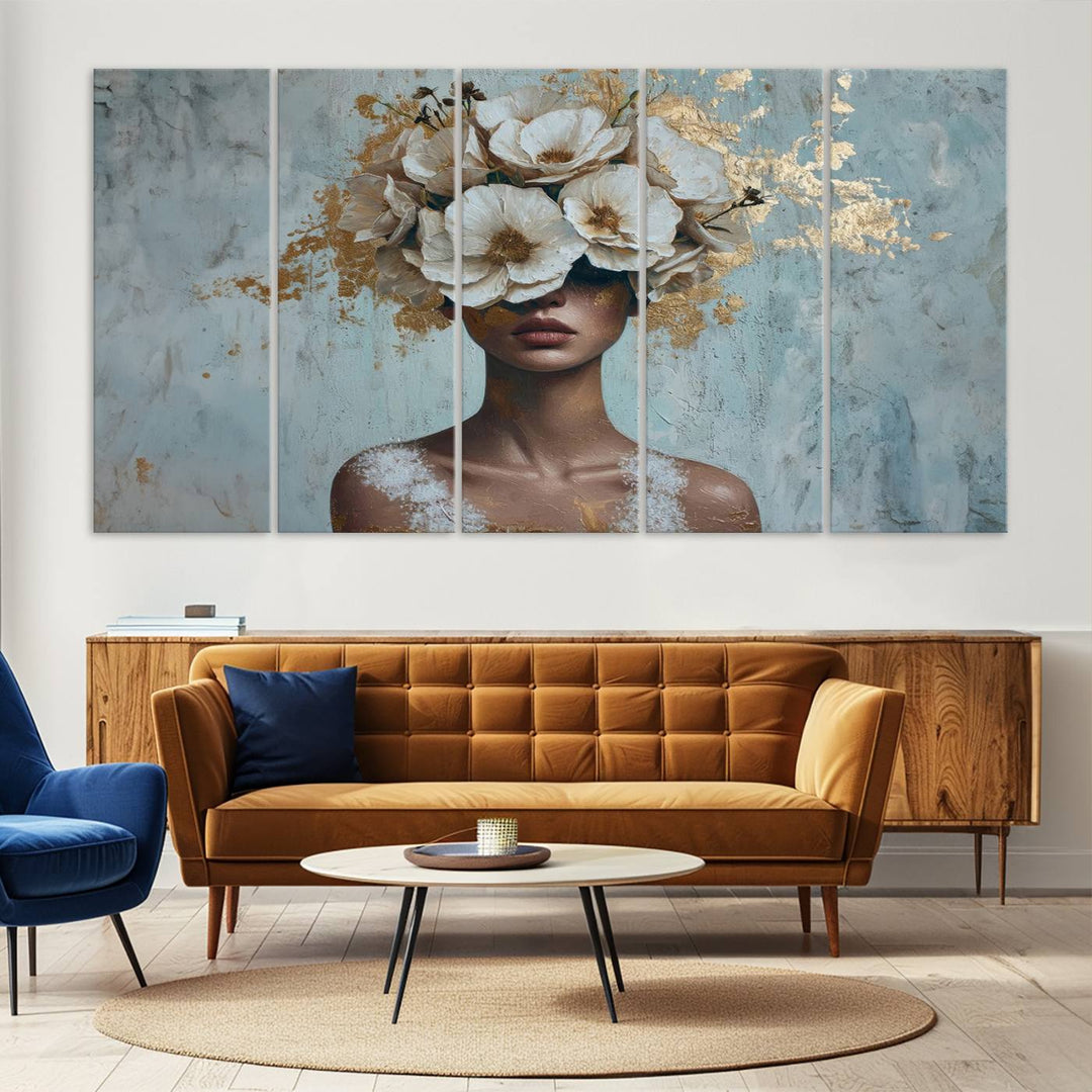 The Golden Petal Silhouette Woman Wall Art Canvas Print, a large 3-panel canvas with a textured gold floral design, serves as a luxurious centerpiece in modern glam settings. The artwork depicts a woman with flowers over her eyes against a textured background and hangs elegantly.