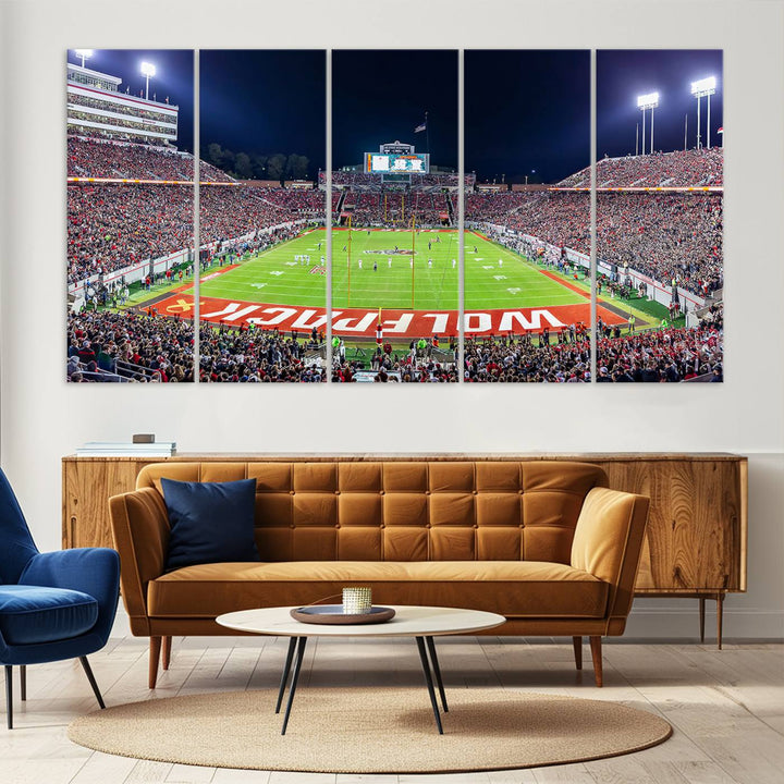 A NC State Wolfpack Football Team print of Carter-Finley Stadium at night features WOLFPACK illuminated brightly in the end zone grass.